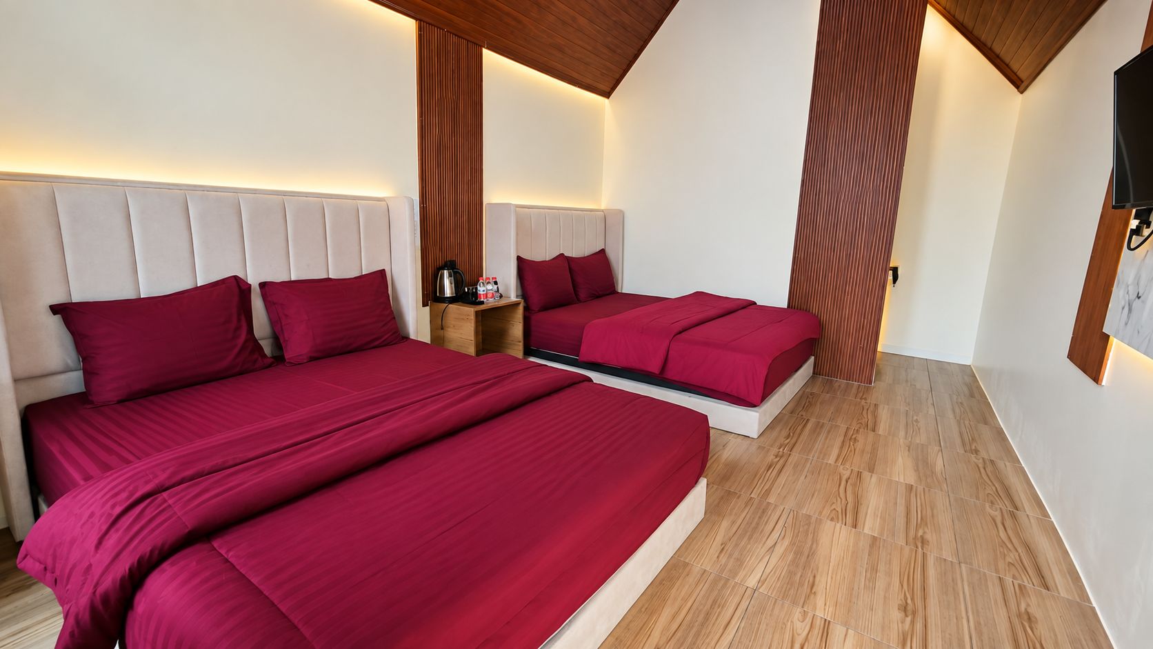 Ein Hotelzimmer mit zwei Betten, Holzboden und modernem Design.