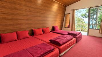 Une chambre d’hôtel avec un plafond en bois, de grandes fenêtres et une moquette rouge.