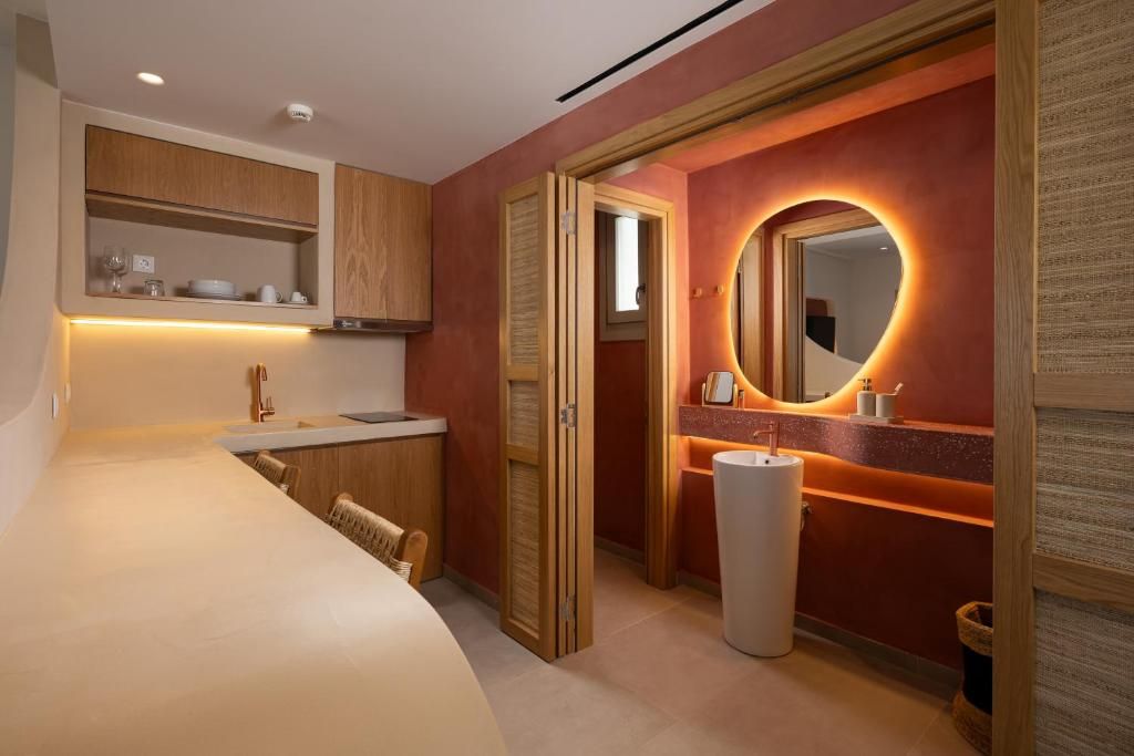 A modern bathroom with a vanity, mirror, and toilet.