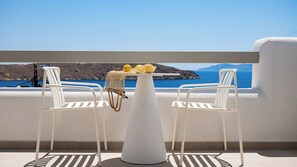 A white table with a basket containing lemons and a net, two white chairs, and a view of the sea and mountains. - Gea Perla Serifos (Serifos)