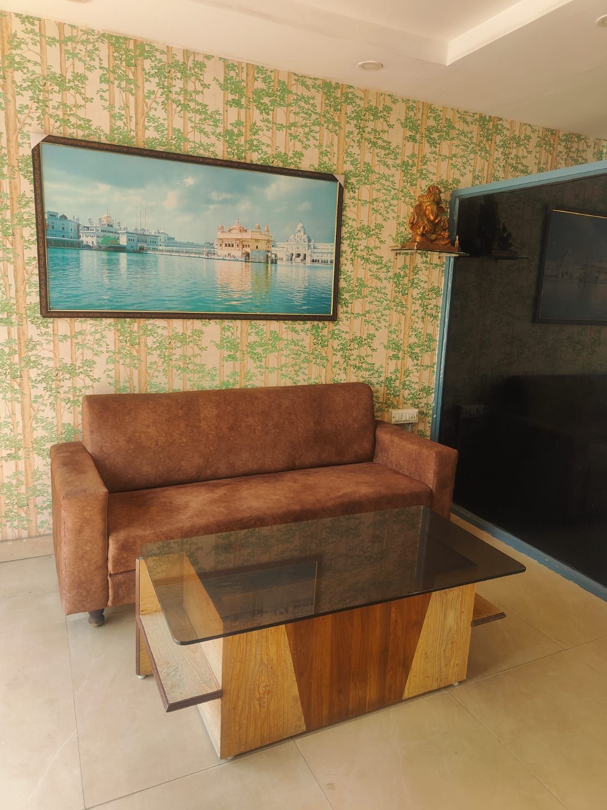 Una sala de estar con un sofá, una mesita de centro y un televisor montado en la pared.