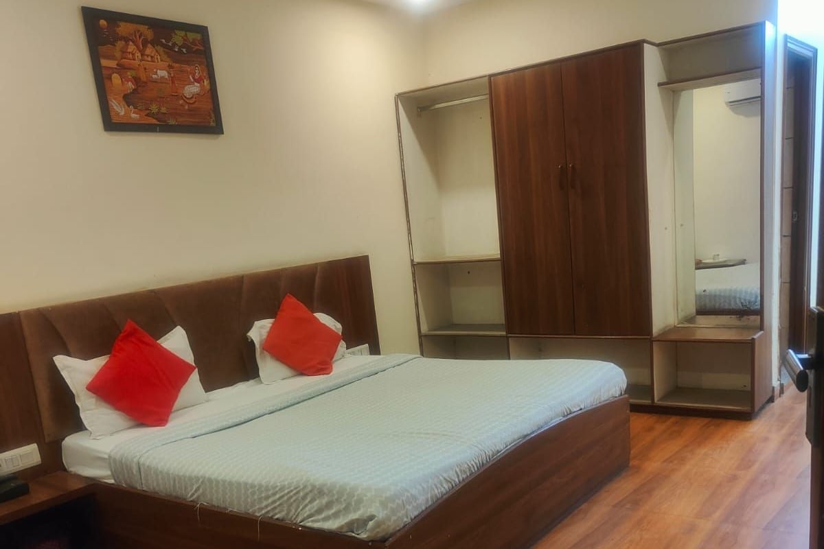 Quarto com cama, guarda-roupa e espelho.