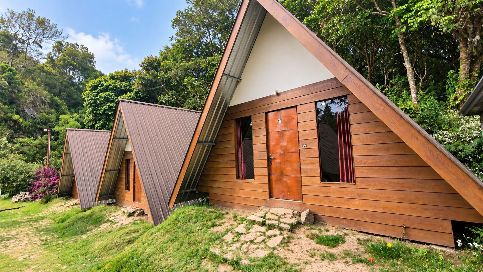 A modern wooden cabin with a sloped roof, large windows, and a door.