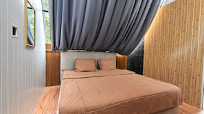 A bedroom with a bed, pillows, a headboard, and a window with curtains. - Sakura Hills (Tawangmangu)