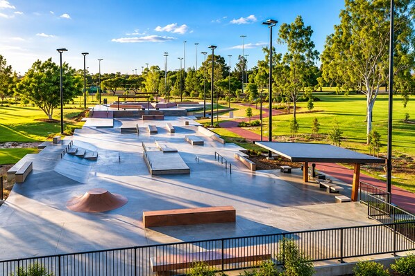 A skate park with ramps, benches, and solar-powered street lamps.
