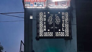 A hotel entrance with a staircase leading up to the door, a reception area, and a gated driveway. - Indian Hotel and Restaurant (Bareilly)