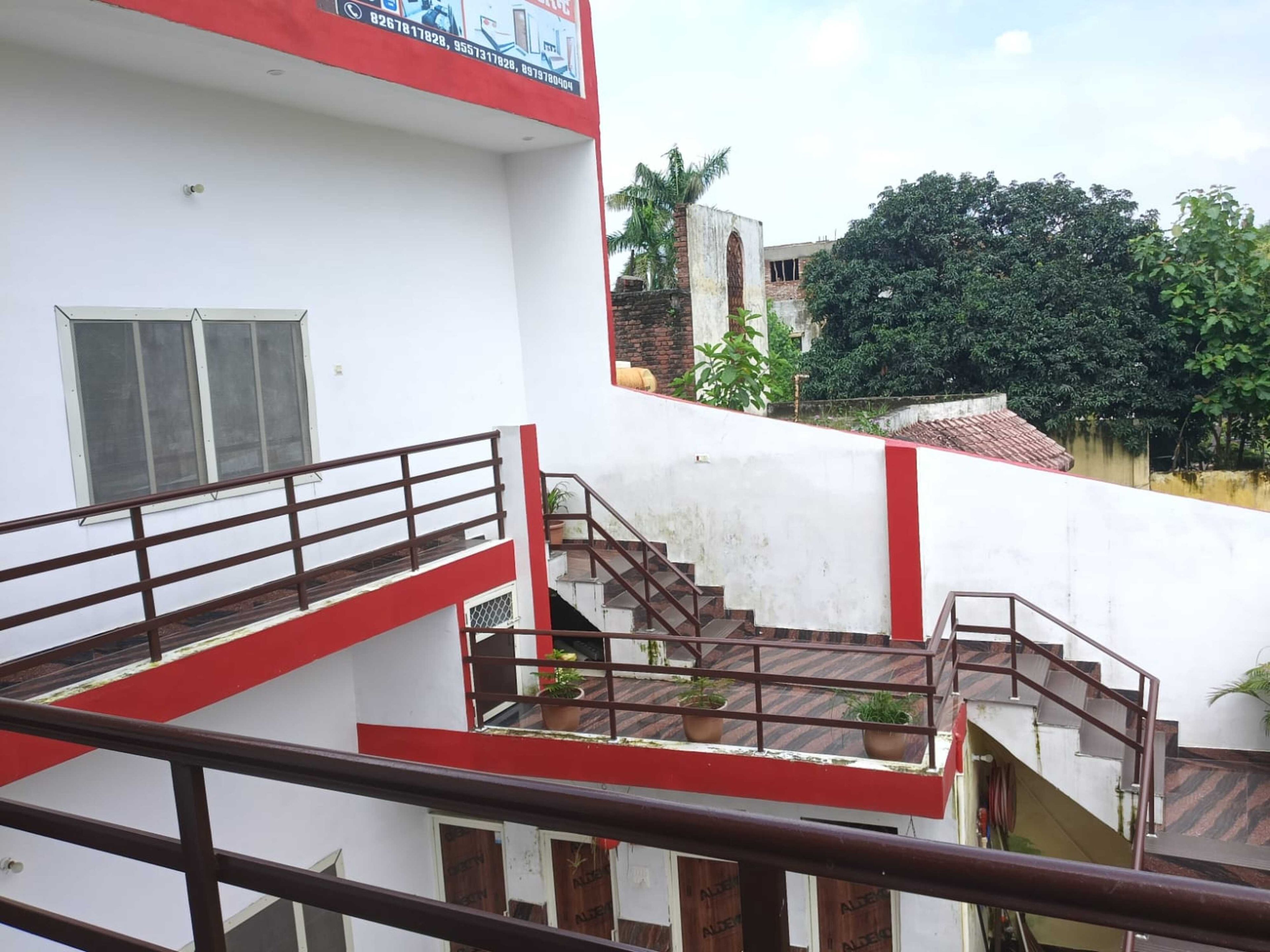 Un edificio de varios niveles con escalera y barandilla roja.