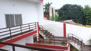 Un edificio de varios niveles con escalera y barandilla roja.
