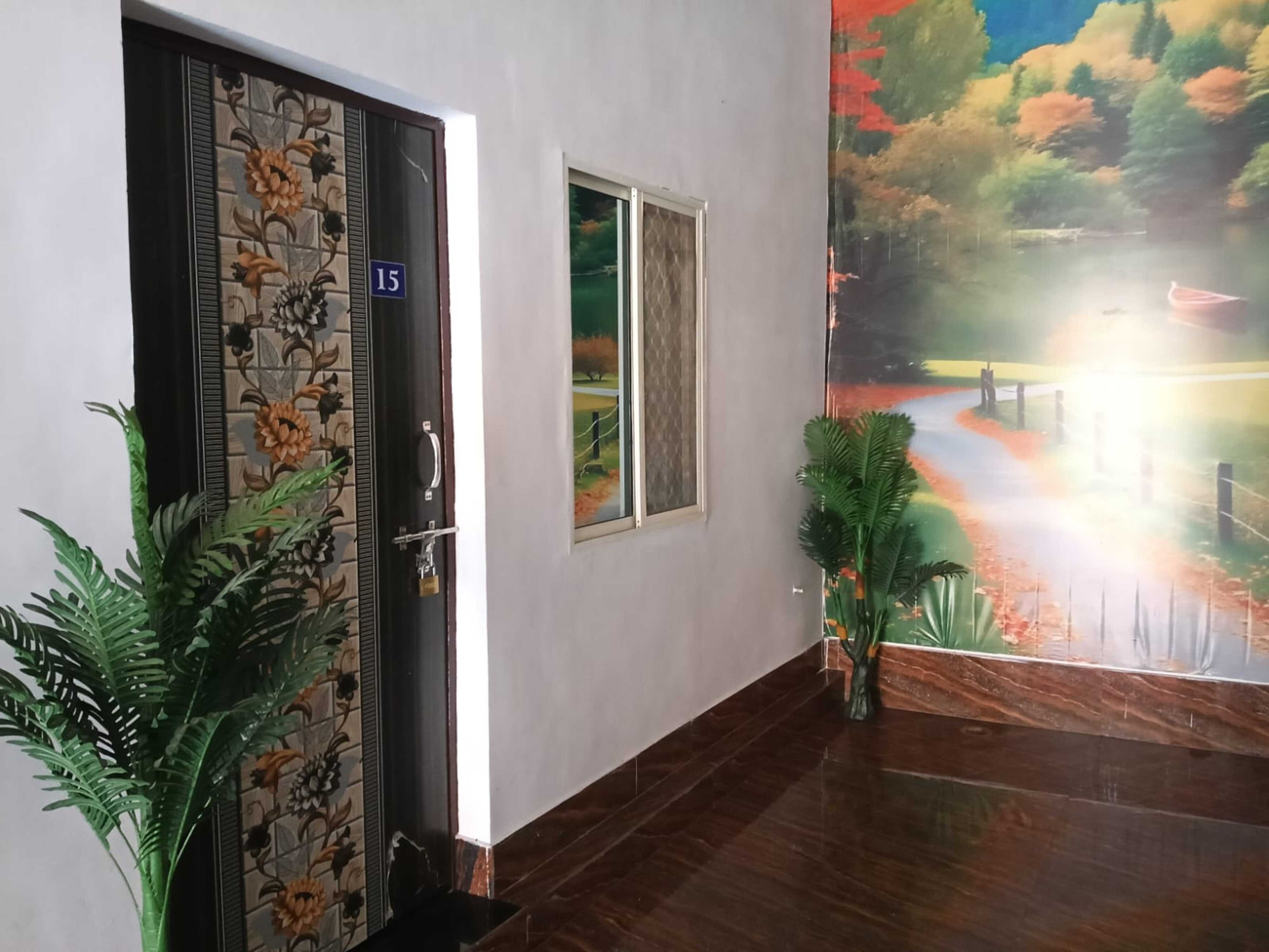 Un pasillo con una puerta marcada '15', un ventanal y un mural de un paisaje.