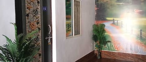A hallway with a door marked '15', a window, and a mural of a landscape.