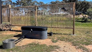 A fenced outdoor area with a fire extinguisher and a hose. - Stringybark by Tiny Away (Rhymney)