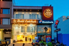 Un edificio con un letrero que indica Hotel Lakshya y Domino's Pizza.