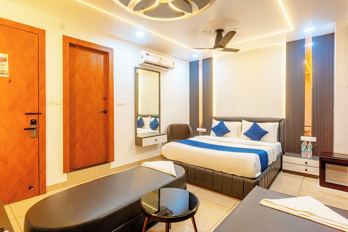 Una habitación de hotel moderna con cama, mesita de noche y un banco.