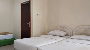 A room with a bed, a green bench, and a door.