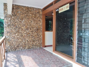 Un mur de pierre et une porte en verre avec une enseigne au-dessus.