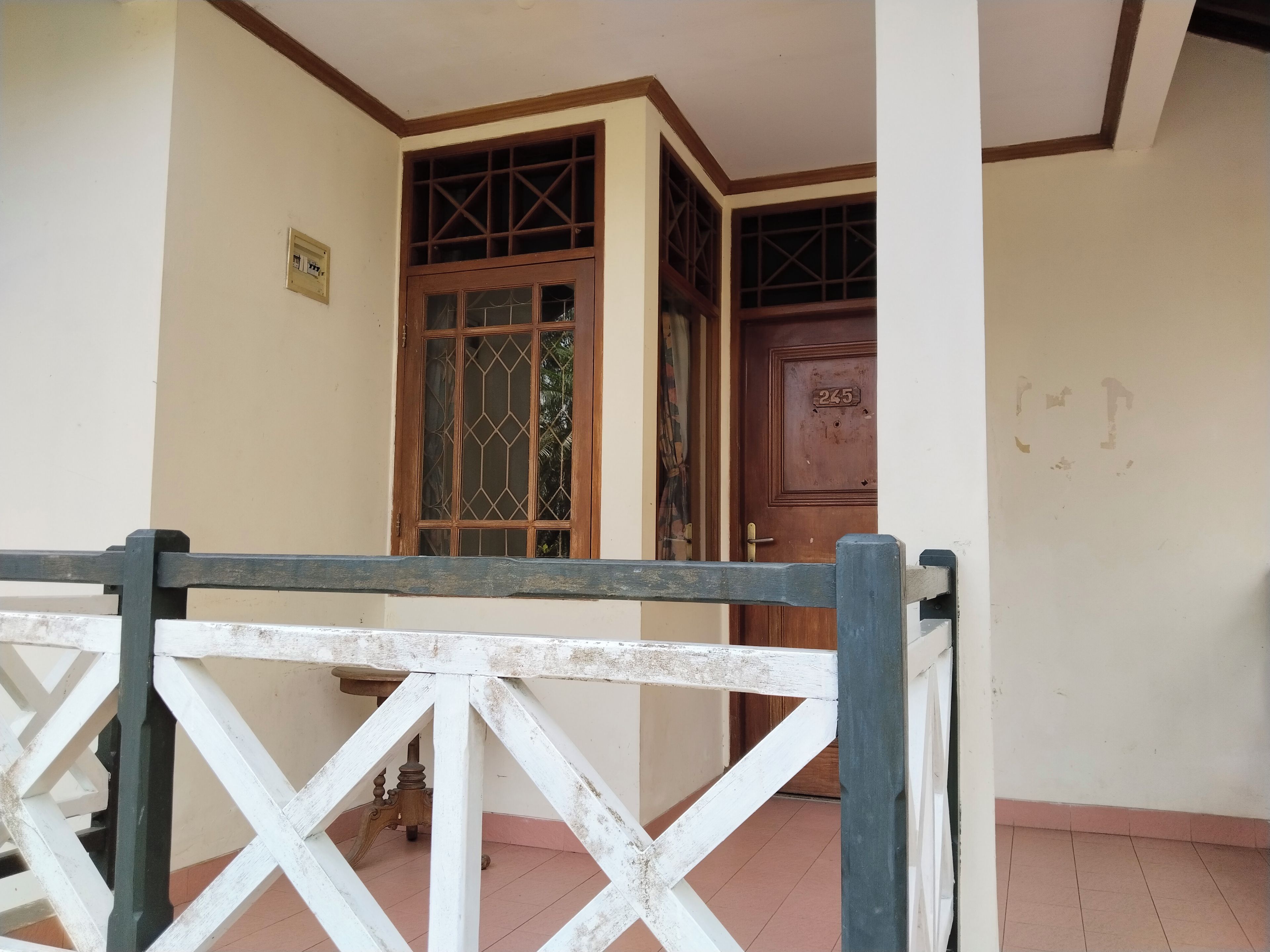 A gated entrance with a wooden door and a window with a grid pattern.