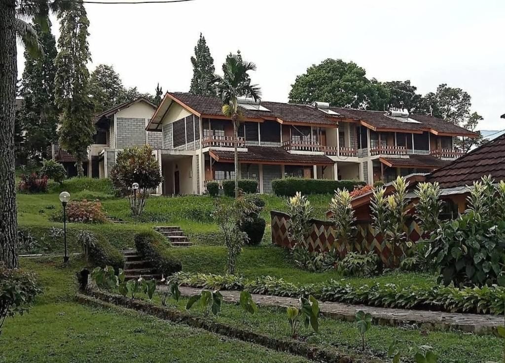 Un edificio residencial de varios pisos con un jardín delantero.