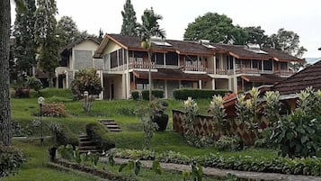 Un edificio residencial de varios pisos con un jardín delantero.