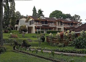 Un edificio residencial de varios pisos con un jardín delantero.