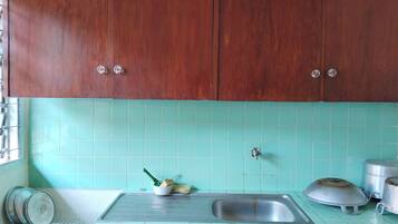 A kitchen with wooden cabinets, a sink, and a tiled backsplash.