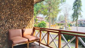 A stone wall, a wooden bench, and a view of a residential area with houses and trees.