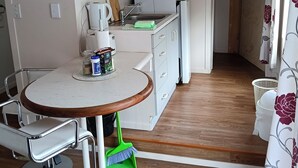 A compact kitchen with a microwave, refrigerator, and a sink. There is a clock on the wall and a sign with the word 'HOPE'. - Water Brook 2 B/R Studio Apt (Hamilton)