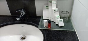 A bathroom sink with a faucet, a soap dispenser, and several bars of soap on a tray. - Renai Green Fields, Kumarakom (Chengalam South)