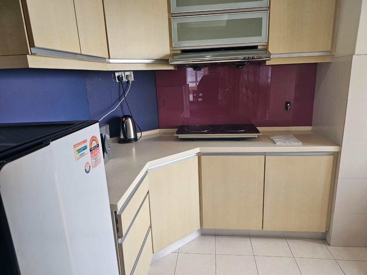 A compact kitchen with a refrigerator, stove, and microwave.