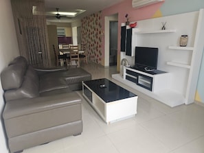 A living room with a sofa, coffee table, TV stand, and decorative items. - Putra Majestik (Kuala Lumpur)