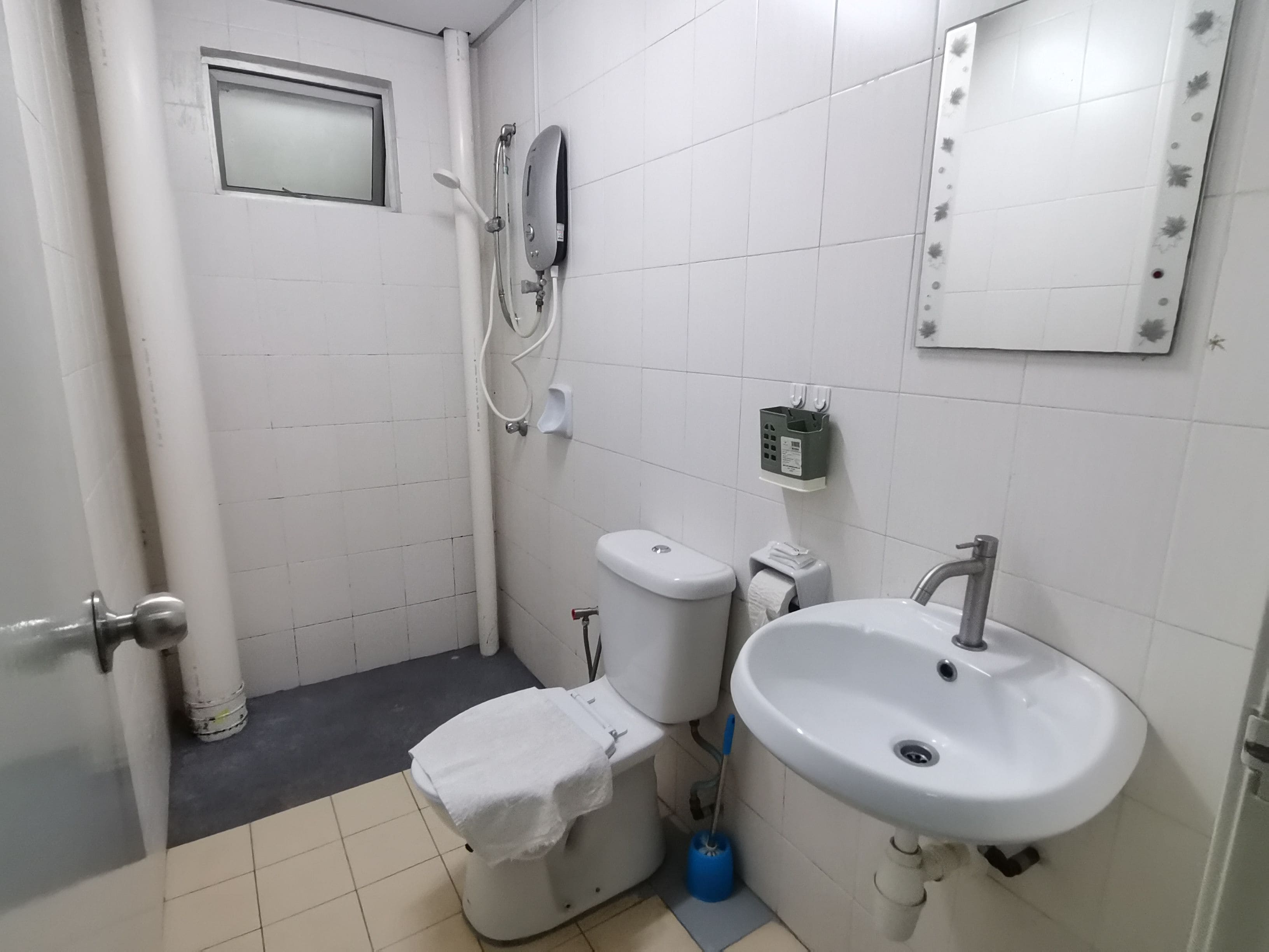 A bathroom with a toilet, bidet, sink, and a towel rack.