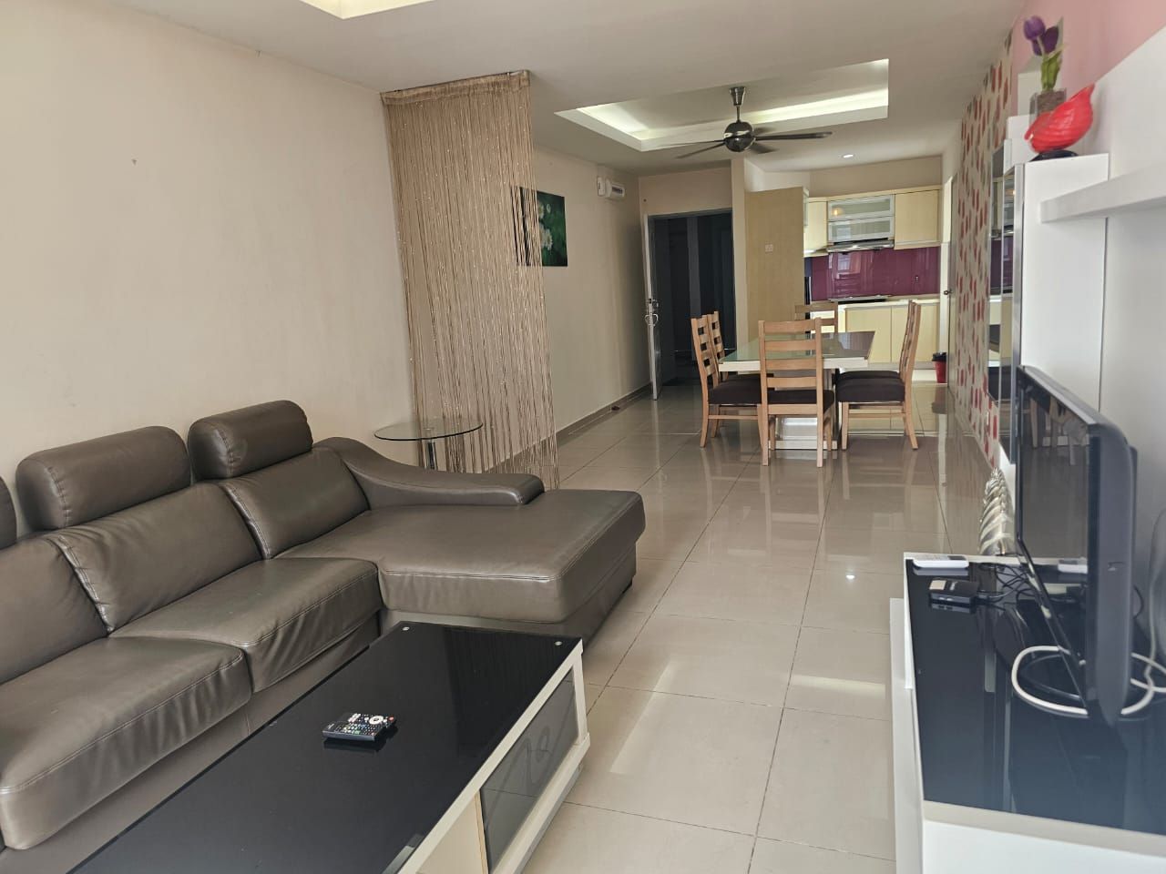 Una sala de estar moderna con un sofá modular, una mesa de centro y un televisor de pantalla plana.