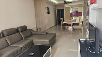 Una sala de estar moderna con un sofá modular, una mesa de centro y un televisor de pantalla plana.