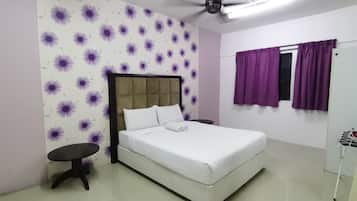 A bedroom with a bed, a ceiling fan, a small table, and a window with purple curtains.