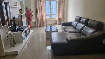 A modern living room with a sectional sofa, a flat-screen TV, and a coffee table.