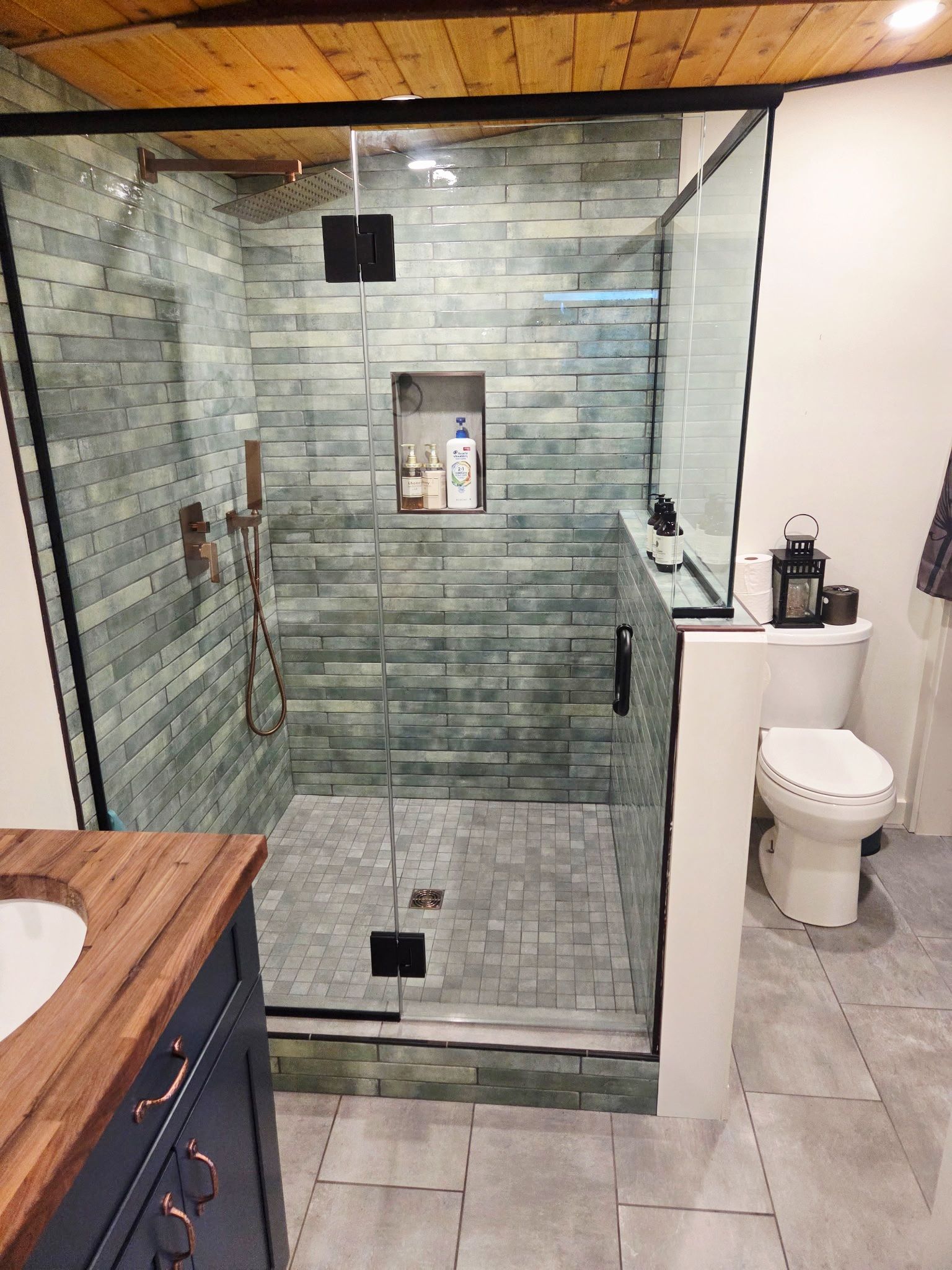 Un baño moderno con ducha de vidrio, inodoro y lavamanos.
