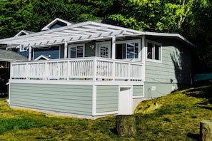 A two-story house with a covered porch and a small deck.
