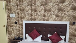 Quarto de hotel com cama, escrivaninha e cadeira.