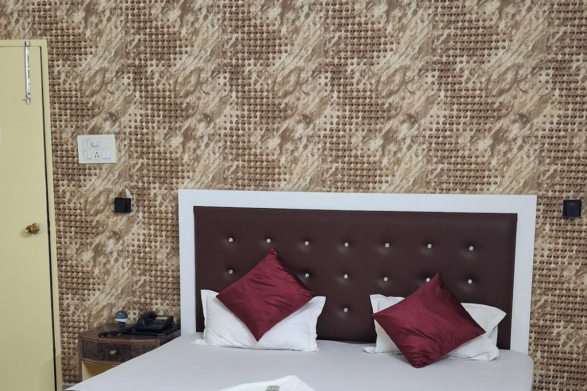 A hotel room with a bed, a desk, and a chair.