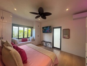 A bedroom with a bed, pillows, a window seat, a TV, and a ceiling fan. - Pool House 311 by Diana (San Juan Cosalá)