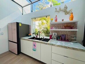 A modern kitchen with a built-in sink, a refrigerator, and a window with a view of greenery. - Pool House 311 by Diana (San Juan Cosalá)