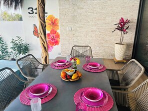 A dining area with a brick wall, a number '31' sign, and a hibiscus flower mural. - Pool House 311 by Diana (San Juan Cosalá)
