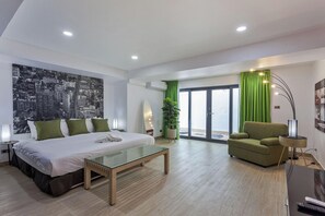 A modern hotel room with a bed, a glass coffee table, a green armchair, and a cityscape wall. - Pratumnak Hill Pool Villa 4BR (PH1) (Banglamung)