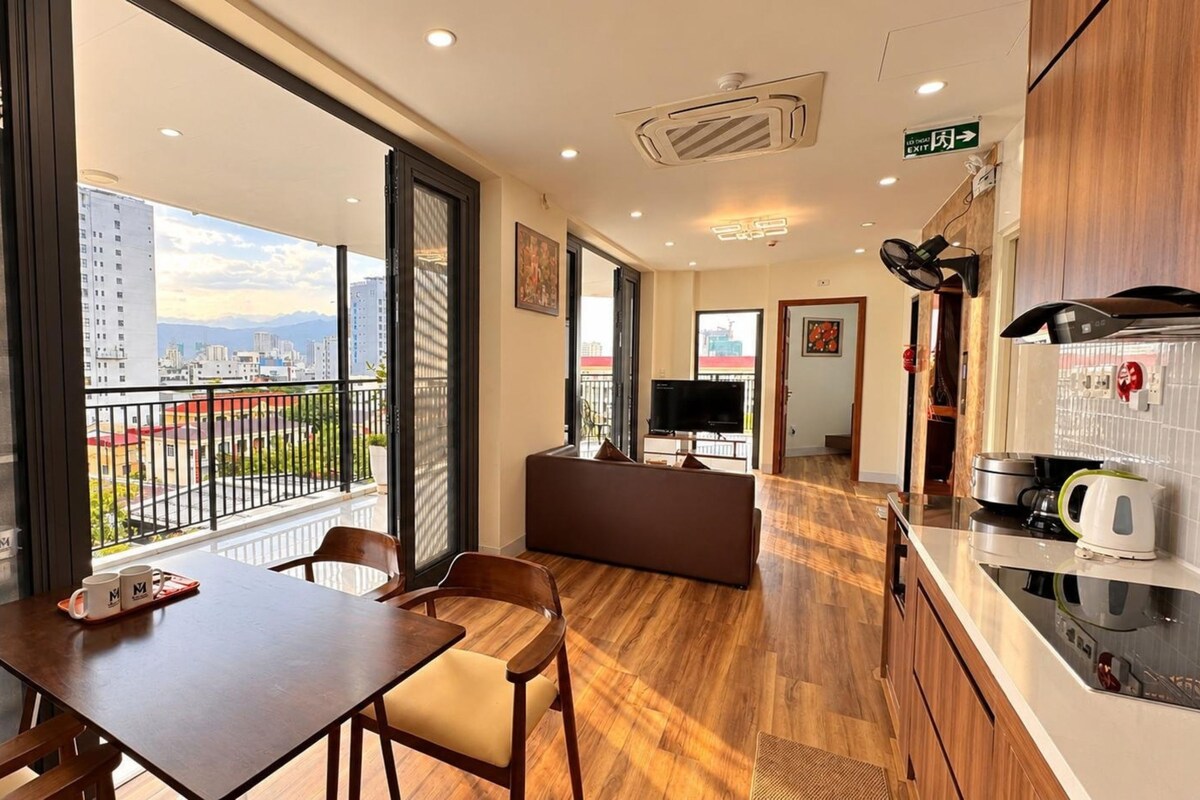 A modern apartment with a balcony, a dining area, a living room, and a kitchen.