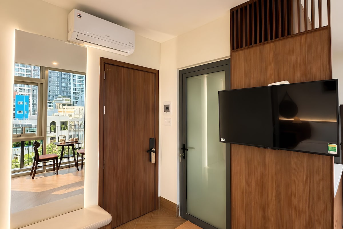Un interior moderno con una puerta de madera, una puerta de cristal y un televisor montado.