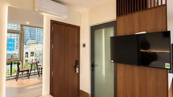 Un interior moderno con una puerta de madera, una puerta de cristal y un televisor montado.