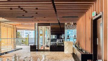Um saguão com um tabuleiro de xadrez, divisória de vidro e design de interiores moderno.