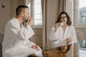A room with a large window, a mirror, and a table.