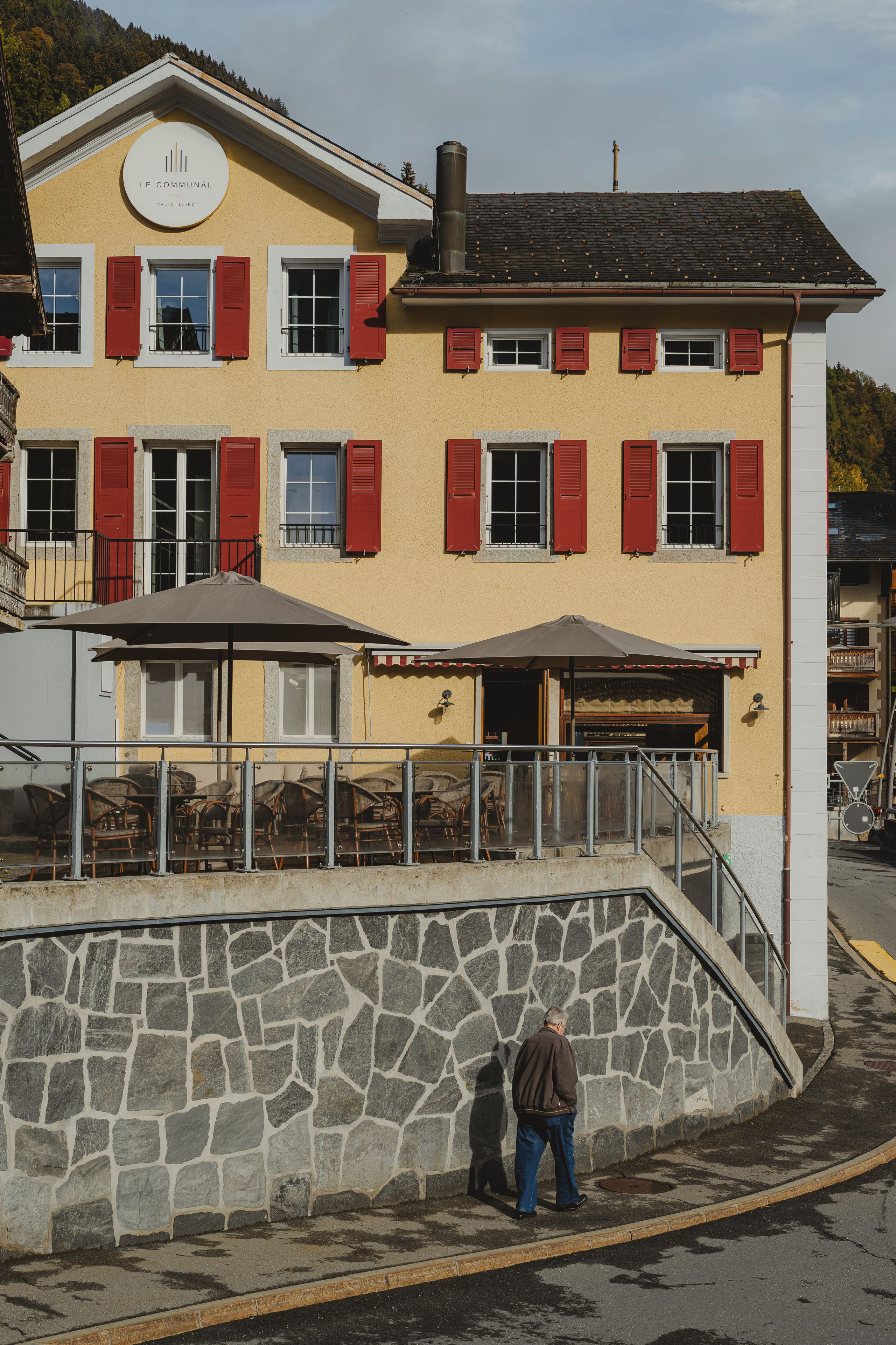 Ein Gebäude mit einer Stein-Fassade, mehreren Fenstern mit roten Fensterläden und einem Schild, das anzeigt, dass es sich um ein Restaurant handelt.