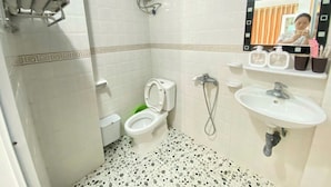 A bathroom with a toilet, bidet, sink, and a shower area. - Cat Ba Thai Long Hotel (Cat Hai)