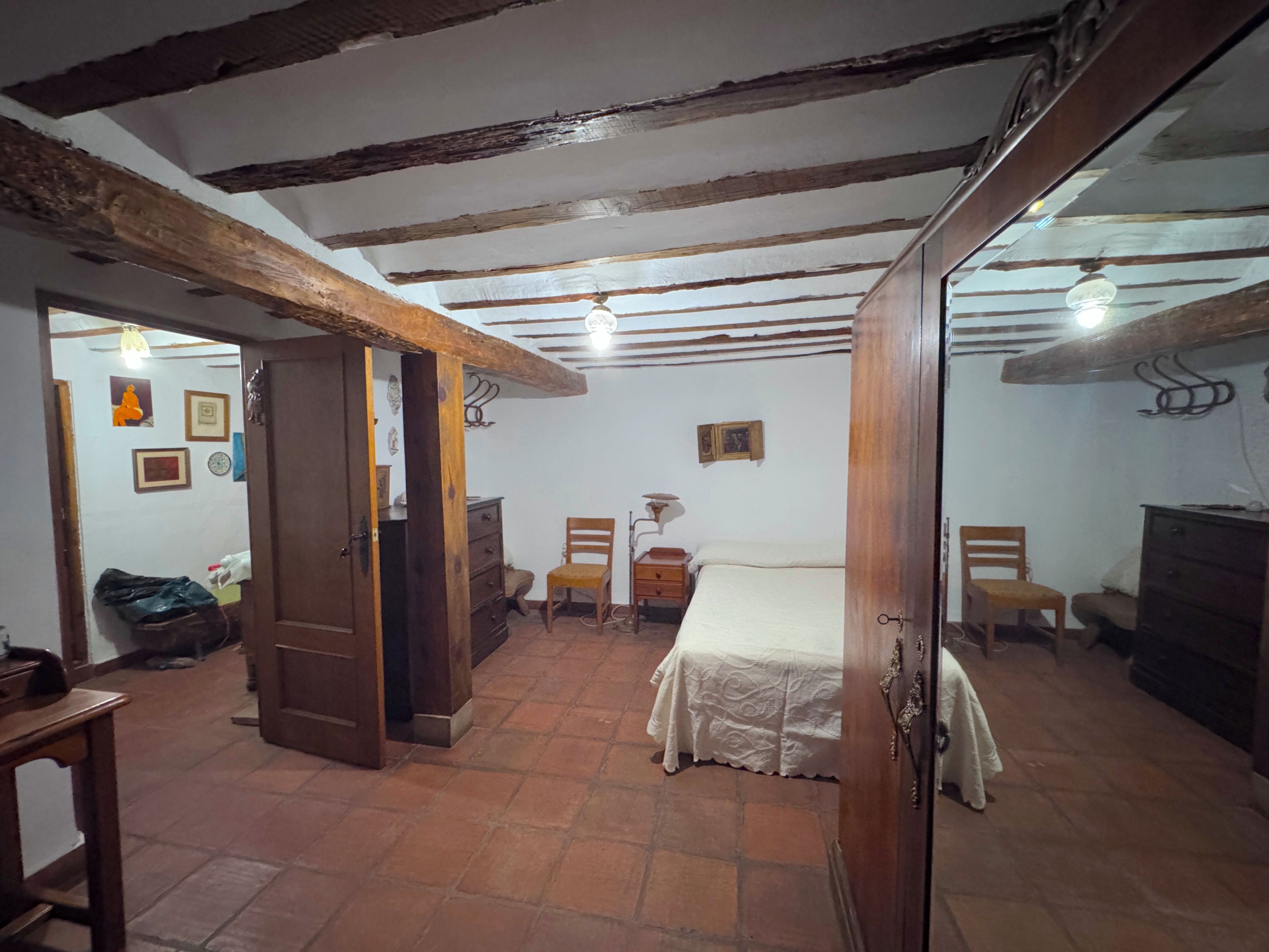 Una habitación con cama, muebles de madera y suelo de baldosas.